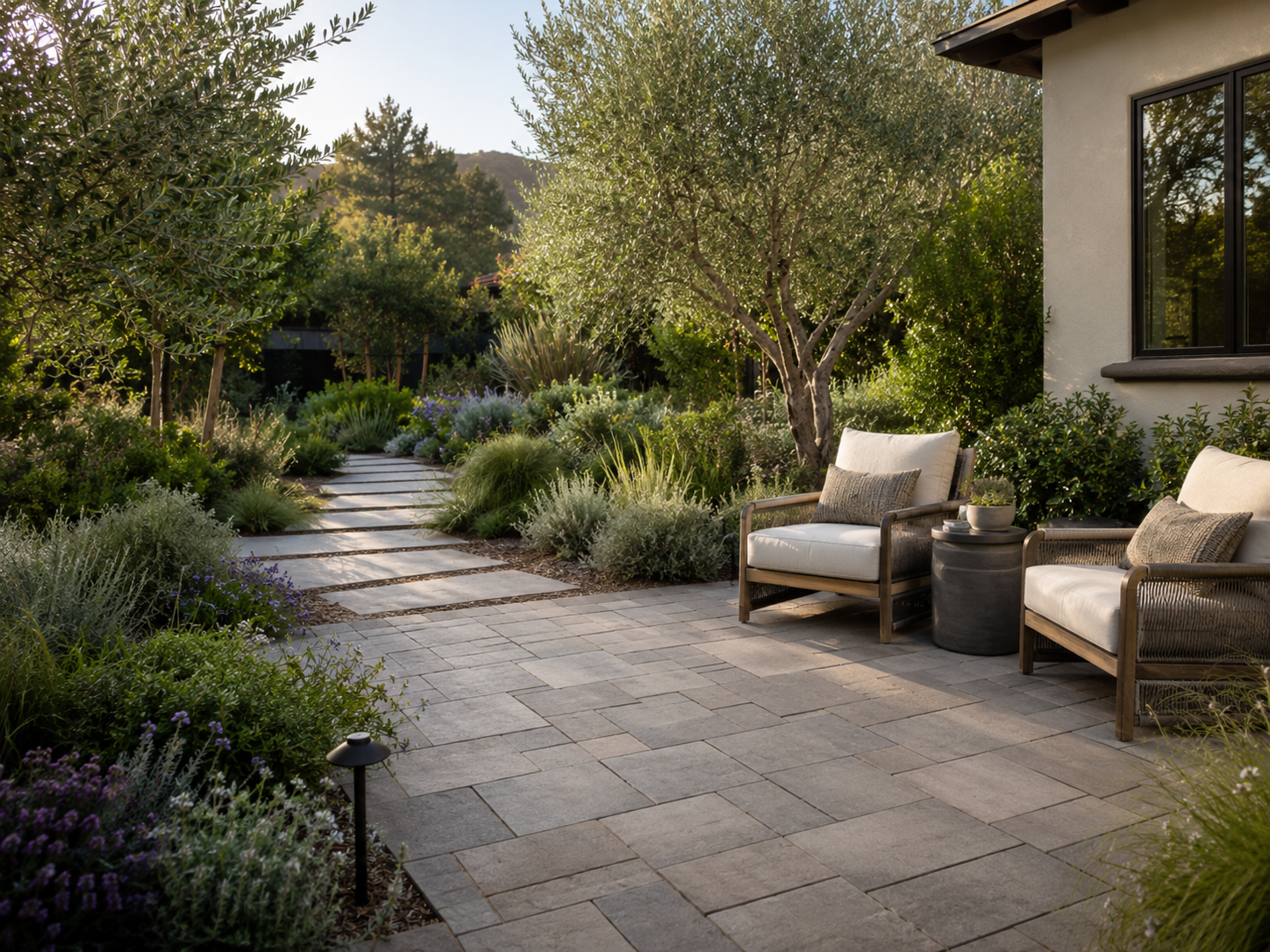 Serene paver garden retreat with comfortable seating and layered greenery